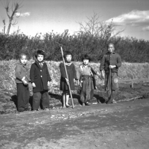 A group of five children of various ages working in a gutter.
